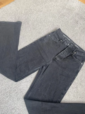 Svarta bootcut jeans från Bikbok - Snygga svarta bootcut jeans från Bilbok med klassisk femficksdesign och hög midja. Jeansen har utsvängda ben och är tillverkade i  denimtyg för en bekväm passform. Perfekta för en trendig och avslappnad stil. Jag är 1,70 och dem är nästan för långa på mig. Dem är storlek 27/32