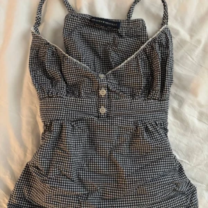 Brandy Melville topp - Jättefin mörkblå/vit rutig Brandy Melville topp som kan knytas i midjan💕Använd 2-3 gånger. Sitter som xs! 