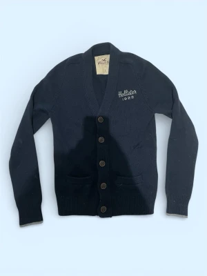 Hollister cardigan (ovanlig) - Säljer nu denna oerhört snygga cardiganen från Hollister! Denna cardigan är sjukt eftertraktad med snygg passform och fin färg. Storleken är L men kan även passa M också. Vid fler frågor är det bara att höra av er!