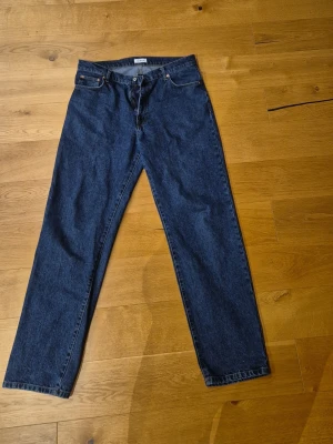 Woodbird mörkblå jeans - Klassiska mörkblå jeans från Woodbird, modell Leroy 90s Rinse med rak passform. Tillverkade i denim med en tidlös look som passar till det mesta. Storlek: W34/L34