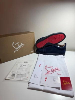 Blåa Christian Louboutin sneakers - Säljer ett par sjukt snygga Christian Louboutin sneakers i mörkblå mocka med den klassiska röda sulan 😮‍💨🔥 Skorna har aldrig använts utan bara testade. Skorna är både sköna och clean och passar typ till allt.  Allt original följer med:  * Box * Dustbag * Kvitto * Tags och tillbehör  Perfekta om du vill ha ett par exklusiva skor som sticker ut utan att vara för mycket.   Skriv vid frågor eller om du vill ha fler bilder 👌 priset är ej hugget i sten så kom gärna med bud!