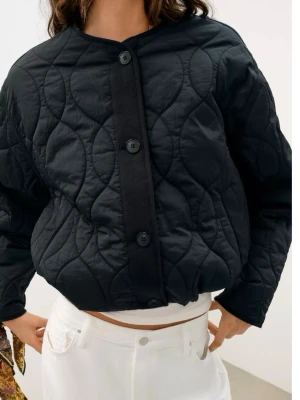 Svart quiltad vindjacka med knappar Zara - Stilren svart vindjacka med quiltat mönster och stora knappar framtill. Jackan har rund halsringning och en boxig, avslappnad passform. Perfekt för lager-på-lager och enkel att matcha till olika outfits.