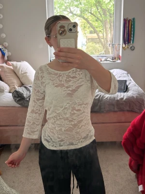 Vit spetsblus med trekvartsärm - Säljer en vit blus i spets med trekvartsärm och rund halsringning. Toppen är lätt transparent och har ett feminint mönster i spetsmaterial. Perfekt att styla med både jeans och kjol. Det är i storlek M men passar också för dom som har S för det är egentligen min storlek!
