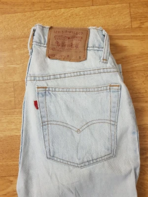 Levi's 512 skum fit - Ljusblå jeans från Levi's modell 512 med slim fit och avsmalnande ben. Klassisk femficksdesign, röd Levi's-tag på bakfickan och läderpatch i midjan. Tillverkade i denim med snygga kontrastsömmar.