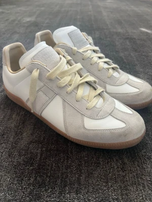 Vita Maison Margiela ”Gats” - Riktigt feta vita gats i storleken 44. Skorna sitter fint och är perfekta inför sommarn. Skorna är bara använda ett fåtal gånger, jag säljer för att dom var för små. Om du har några frågor är det bara att höra av dig!😃 inget pris är hugget i sten🤝