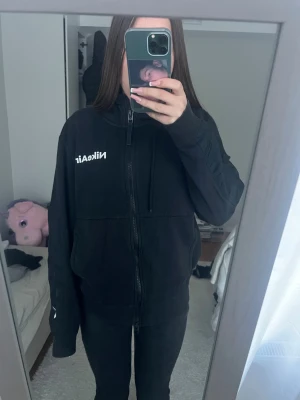 Svart Nike Air zip-hoodie med huva - Säljer en svart zip-hoodie från Nike Air med vit logga på bröstet. Hoodien har dragkedja hela vägen, två fickor fram och en skön huva med dragsko. Perfekt för en chill och sportig look.
