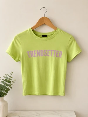 Limegrön T-shirt från Bershka - Trendig limegrön T-shirt från Bershka med lila texten 'TRENDSETTER' framtill. Modellen är croppad med korta ärmar och rund halsringning. Perfekt för dig som vill sticka ut med färg och stil.