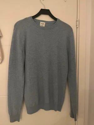 Ljusblå cashmeretröja John Henric - Mysig ljusblå stickad tröja från John Henric i 100% cashmere. Klassisk rund halsringning och ribbade muddar vid ärmslut och nederkant. Perfekt för dig som gillar stilrena och bekväma plagg. Litet hål i armhålan som inte syns, kolla sista bild. 