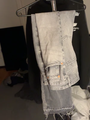 Baggy jeans - Säljer ett par gråa raka jeans med snyggt tvättad look och råa, fransiga benslut. Jeansen har klassiska fickor och synliga nitar. Perfekta för en avslappnad och trendig stil. Inte min stil längre
