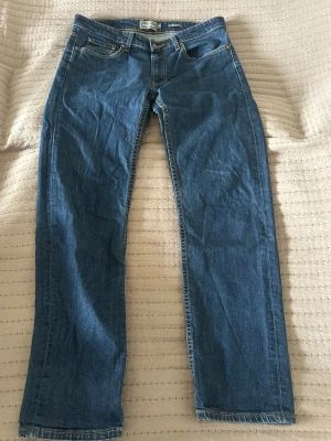 Blå regular fit jeans från Dressmann - Säljer ett par klassiska blå jeans från Dressmann i regular fit. Jeansen har fem fickor, raka ben och är gjorda i slitstarkt denimtyg. Perfekta för dig som gillar en tidlös och enkel stil.