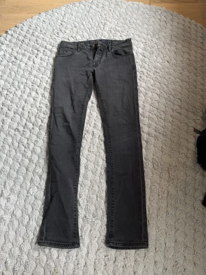 Grå jeans från Jacob Cohen - Snygga grå jeans från Jacob Cohen med klassisk femficksmodell och raka ben. Jeansen har bälteshällor, knappgylf och diskreta sömmar. Perfekta för en stilren och avslappnad look.
