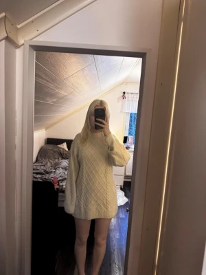 Stickad klänning - Beige långärmad stickad miniklänning, är kabelstickad på framsidan och slät på baksidan. Endast använd ett fåtal gånger och är i väldigt bra skick.