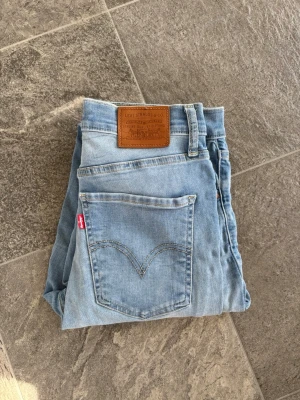 Levi's Mile High Super Skinny jeans - Säljer ett par ljusblå Levi's Mile High Super Skinny jeans med klassisk femficksdesign och hög midja. Jeansen har en snygg skinny fit och är tillverkade i mjukt denim med stretch. Perfekta för dig som gillar en tight och modern look. För mer bilder skriv privat 
