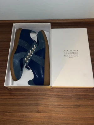 Blå Maison Margiela  - Säljer ett par feta Maison margiela skor i storlek 43. Sjukt feta skor och de är helt oanvända. Skriv vid minsta funderingar!