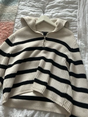 Randig stickad tröja från Lindex - Säljer en vit stickad tröja med nacke och mörkblå ränder . Tjock och skön att ha på sig. 