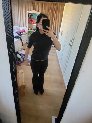 Svart stickad topp med halvärm - En enkel och stilren svart stickad topp med halvärm och rund hals. Passformen är normal och toppen är perfekt att matcha med både jeans och kjol. Materialet känns mjukt och bekvämt mot huden.