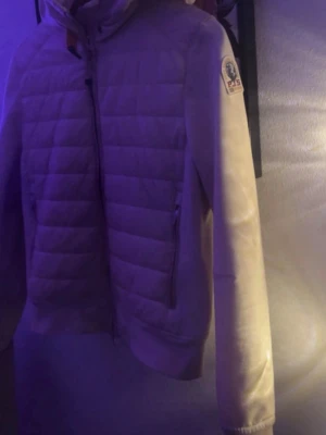 Beige pufferjacka från Parajumpers - Säljer en beige pufferjacka från Parajumpers med quiltad front, hög krage och dragkedja. Jackan har en patch med logga på ärmen och sidofickor med dragkedja. Perfekt för kalla dagar och riktigt snygg till streetwear-stilen.