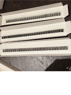 Svarta fransförlängningar i remsor - Säljer tre remsor med svarta fransförlängningar i naturlig form. Fransarna är täta och har en lätt böjd design för att ge volym och längd till ögonfransarna. Perfekta för dig som vill ha en markerad ögonlook. Kommer i vita askar.