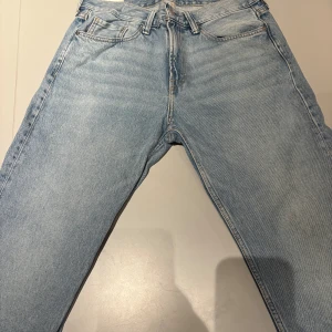 Ljusblå raka jeans - Säljer ett par ljusblå jeans med rak passform och klassisk femficksdesign. Jeansen har normal midja.  Perfekta för en avslappnad och trendig look.