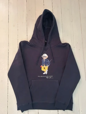 Ralph Lauren polo bear hoodie herr, storlek M - Hej! Säljer denna riktigt schyssta polo bear hoodie från Ralph Lauren. Den är i storlek L men sitter en storlek litet och passar därför som en M. Den är endast använd någon enstaka gång och är därmed i ett nyskick. Original lappar och påse finns kvar och medföljer naturligtvis vid köp. Jag fraktar alltid snabbt! Mvh