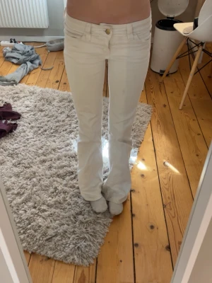 Vita bootcut jeans  - Säljer ett par vita bootcut jeans från Cheap Monday med klassisk femficksmodell och logga på bakfickan. Jeansen har låg midja och är tillverkade i ett stretchigt bomullsmaterial för skön passform. 