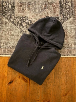 Svart/Mörkgrå Ralph Lauren Hoodie - Hej!👋  Säljer en svart/väldigt mörkblå hoodie från Polo Ralph Lauren. Den har små missfärgningar, som till huvudsak är på baksidan, (se de två sista bilderna). Vet ej om de går bort i tvätten. Utöver detta så är den i mycket fint skick! Storlek M Hör av er vid frågor om mått eller annat!💯  #PoloRalphLauren #RalphLauren #Polo #RL #PoloHoodie #PoloSport #OldMoney #QuietLuxury #Preppy #Streetwear #ClassicStyle #Menswear #WhiteHoodie #VintedFinds #Hoodie #HoodedSweatshirt #Sweatshirt #Tröja #Huvtröj