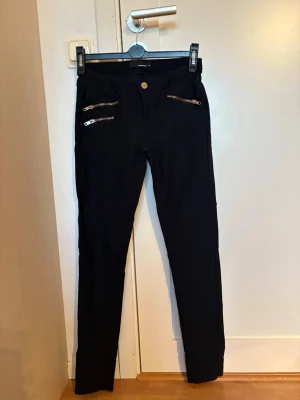 Svarta skinny jeans med dragkedjor - Snygga svarta skinny jeans med två  dragkedjor framtill.