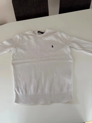 Vit stickad tröja från Ralph Lauren - Väldigt bra kondition inte så mycket använd under pga den blev för liten annars inga fel förutom att lappen där det står ralph lauren har gått av vid ett hörn annars är allt som det ska vara