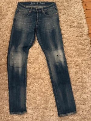  Jack & Jones - Säljer ett par riktigt goa jeans från Jack and Jones med slitningar, storleken är 31/34 så skulle säga att de passar om man är 180 cm +