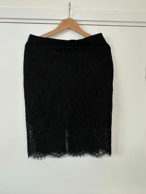Svart spetskjol - helt NY - Helt NY elegant svart fodrad kjol i spets från Prepair i storlek L (modell Doreen). Dold dragkedja i sidan och en liten sprund baktill. Otroligt fin, men tyvärr för liten för mig.   (Skickas mot porto, men kan även hämtas i Stockholm om det är extra bråttom).