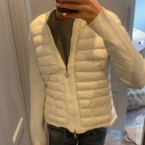 Vit Moncler Cardigan - Säljer en supersnygg äkta moncler cardigan. Den är i storlek M men passar även S/Xs. Perfekt för många tillfällen! DEFEKTER finns så som lappen man hänger på har släppt i sömmen och lite små fläckar men inget man tänker på. Pris kan diskuteras💕💕