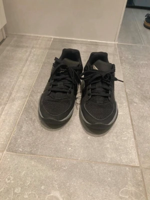 Svarta sneakers från 12:AM - Snygga svarta sneakers från 12:AM med grå detaljer och meshpartier för extra andningsförmåga. Skorna har klassisk snörning och låg profil, samt logga baktill. Perfekta för en stilren och sportig look.