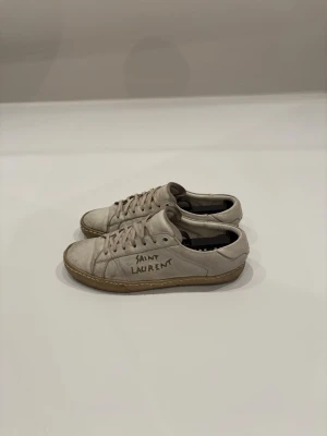 Saint Laurent -  Säljer ett par vita Saint Laurent skor i storlek 41. Hör av dig vid minsta lilla fråga