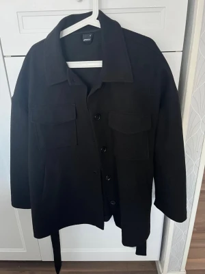 Svart overshirt från Gina Tricot - Svart kort kappa från Gina Tricot i storlek M. Jätte bra skick.