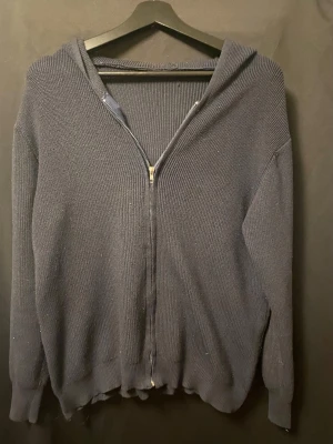 Stickad zip-tröja (inkl. gratis frakt) - Säljer en klassisk  fräsch marinblå hoodie i stickat material. Ett perfekt basplagg som passar till det mesta! Koftan har en rejäl dragkedja framtill, en rymlig huva och ribbstickade muddar vid ärmsluten och i nederkanten för en snygg passform. Materialet har en fin struktur och känns rejält men mjukt. 