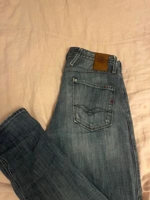 Replay jeans - Säljer dessa replay jeans med snygg fade o svin snygga slitningar på framsidan! Fint skick utan defekter. Storlek 30-32 men sitte sitter lite smått i midjan!