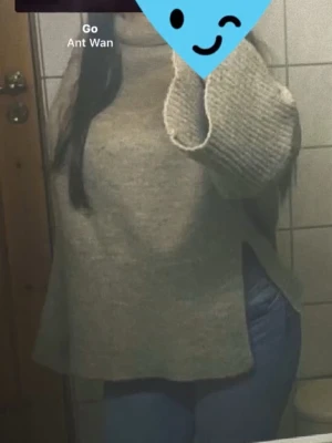 Beige polotröja i stickat material - Mysig beige stickad polotröja med breda ärmar och avslappnad passform. Tröjan har ribbstickade muddar vid ärmslut och hals, perfekt för lager på lager och en chill look. Passar till jeans eller kjol för en enkel stil.