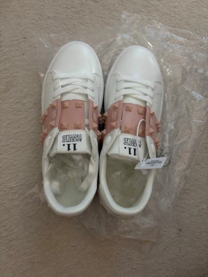 Rockstud sneakers med rosa nitar - Säljer dessa skitsnygga valentino skor då de tyvärr var för små på mig💔har storlek 40-41 men eftersom de är alldeles för små skulle jag tro de passar de med storlek 39 bättre perfekt nu till sommarn💗pris kan diskuteras för de som vill