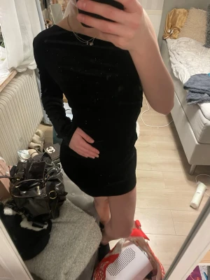 Svart kort klänning med lång ärm - Säljer en svart, tight kortklänning med lång ärm och enkel, stilren design. Materialet känns mjukt och stretchigt. Storlek S från h&m, aldrig använd. 