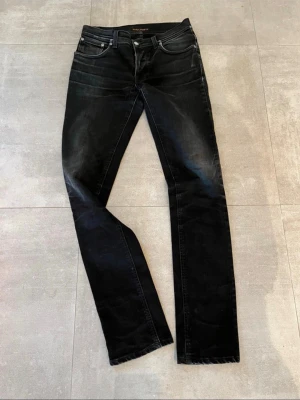 Nudie Jeans Grim Tim - Riktigt feta Nudie Jeans i modellen Grim Tim. Färgen heter ”Dry Cold Black”. Skicket är riktigt bra. Storleken är 32/36 men något små i storlek så hör av er för mått eller andra frågor vid osäkerhet. 