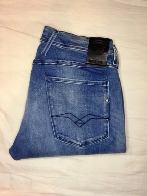 Replay jeans – stretch – clean fit  - Snygga Replay-jeans i grym blå tvätt. Stretchigt och bekvämt denim som sitter riktigt bra. Perfekt vardagsjeans med clean look – lätt att styla.  ✅ Bra skick ✅ Stretch material ✅ Tidlös passform  Mått (platt mätta): Midja: 42 cm Längd (ytterben): 104 cm Innerben: 82 cm Benslut: 17 cm  Snabb affär uppskattas 💙 👉 Kolla min profil för mer info och fler annonser.