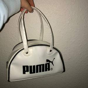 En vit Puma handväska som inte kommer till användning. Väskan har ett stort utrymme i och håller din struktur. Handväskan är även lätt att torka av för att vara vit. Älskar denna väskan dock använder jag den för lite för att ha kvar. Köptes ny för 450 kr.