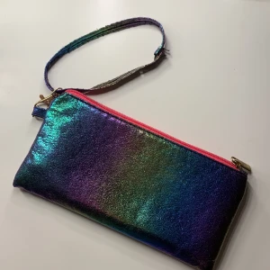 ”Metall regnbågig” väska/nessesär/pennskrin - Jag säljer en väska/nessesär/pennskrin som har använts 1-3 gånger den är lite sönder på bandet men det går att ta av det också. Den är 3-5 år gammal men helt fungerande. Den skiner när man har det vid ljus som man kan se på bilderna. 💓🫶🏼