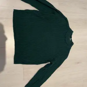 En mörk grön ribbad tröja från H&M i bra skick.