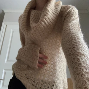 Stickad tröja - Unik Beige stickad tröja som är lite guld glittrig i nyansen med en  stor ”nacke” som håller värmen samtidigt som den är så snygg och verkligen gör hela outfiten!⭐️ 