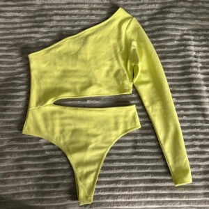 Bodysuit topp - Enärmad body med öppning nertill. Bara använd två gånger. Lime färgad.