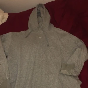 Grå Nike hoodie - Superfin ljusgrå Nike hoodie. Har blivit lite nött vid mudden men märks knappt. Annars fint skick. Strl xs, passar även s unisex