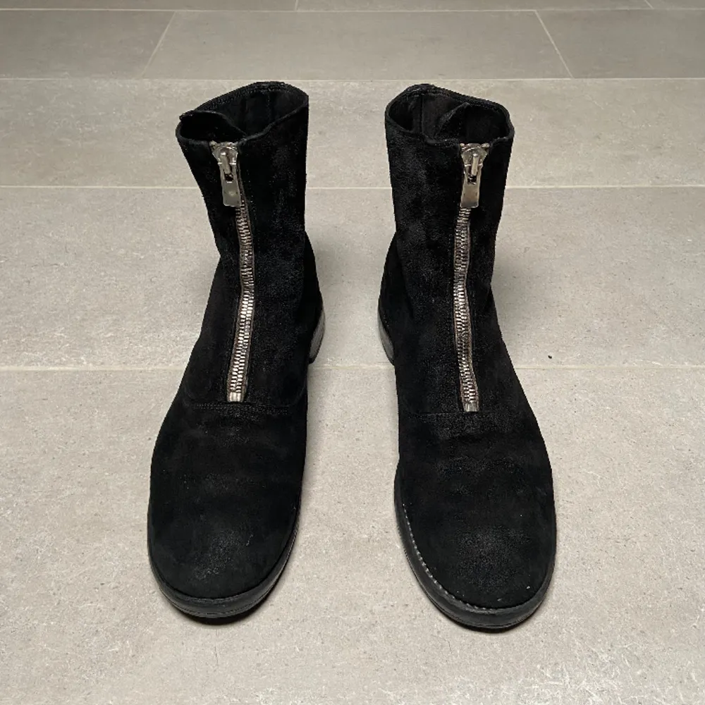 Svarta Guidi frontzips gjorda av mocka. Skorna är från innan 2010 men i mycket välbevarat skick. Den skyddande gummi sulan skulle behöva bytas ut. Skorna är storlek 45 men passar 45-46.. Skor.
