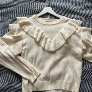 Stickad tröja med volanger  - Vit stickad tröja med volanger som sitter superfint! Den är krämvit och har inga defekter. Den är från loavies i storlek XS