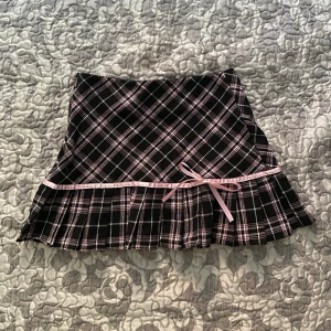 Rutig coquette kjol med rosett - midjan & längden är 33cm, har en dragkedja 🩷tryck INTE på köp nu 